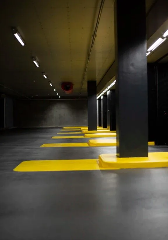 Garage privé haut de gamme avec Range Rover et BMW, sol résine beige clair, éclairage LED intégré